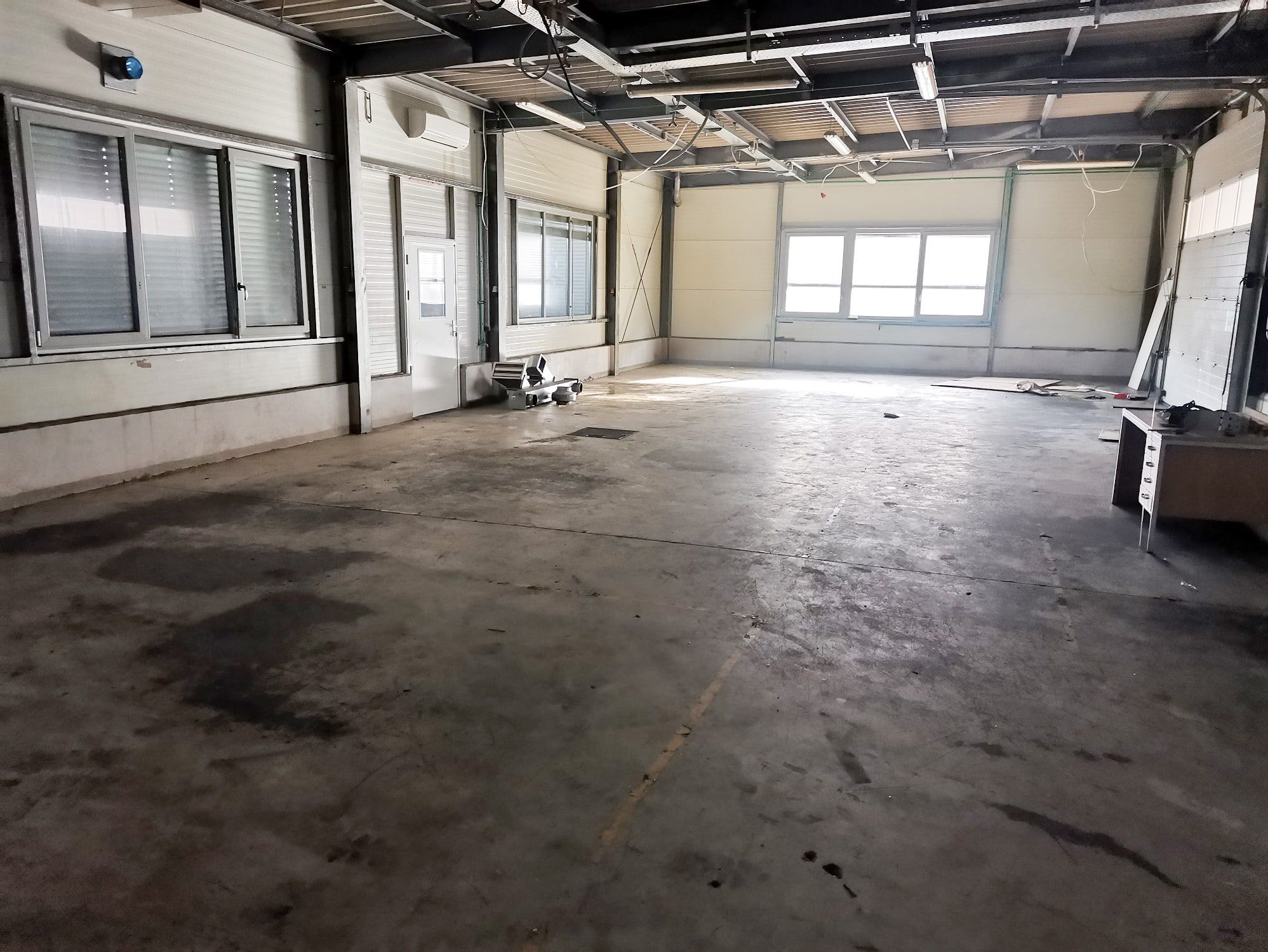 Before: Same hall, another area: from oil-soaked concrete to a sealed surface